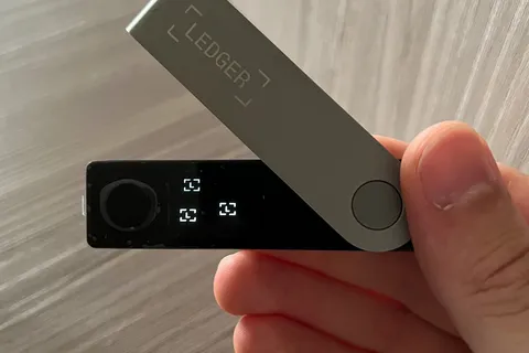 A Ledger hardware crypto wallet with its cable
