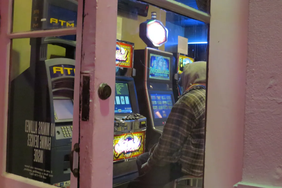 Video gaming machines and an ATM inside a bar, seen through an open door