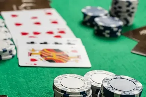 Poker chips and playing cards spread across green felt